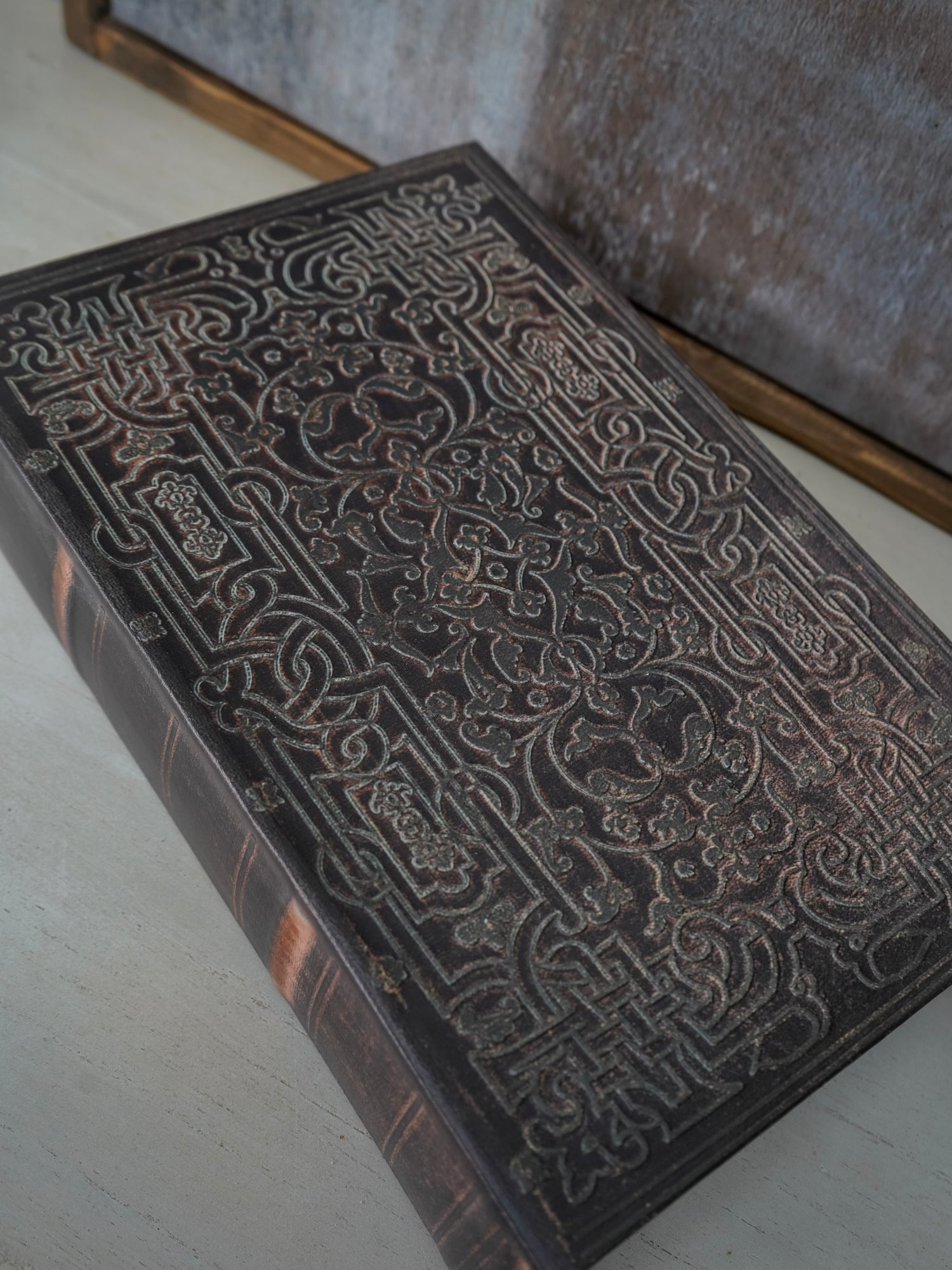 Decorative wooden box with intricate carvings on a light surface