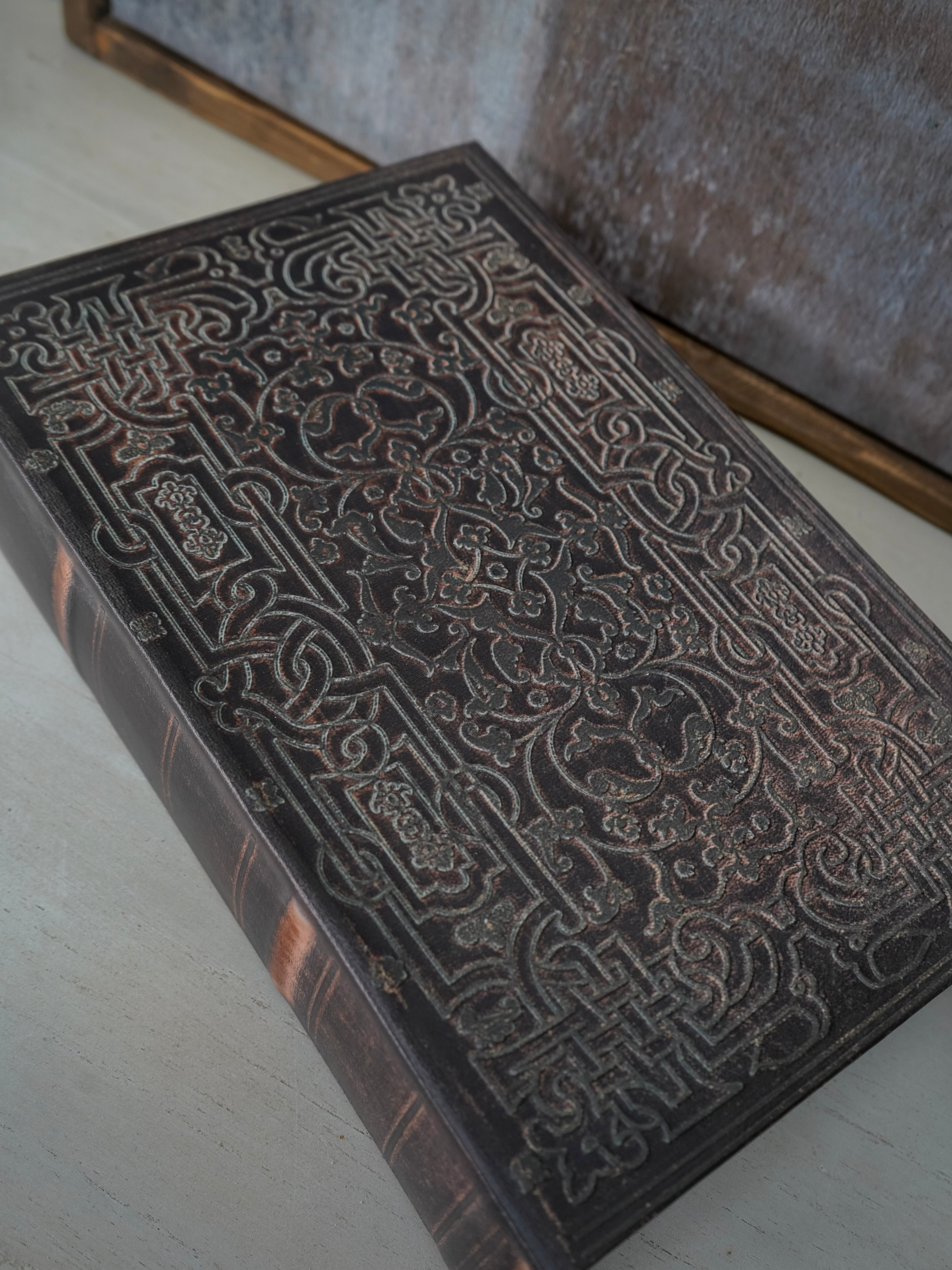 Decorative wooden box with intricate carvings on a light surface
