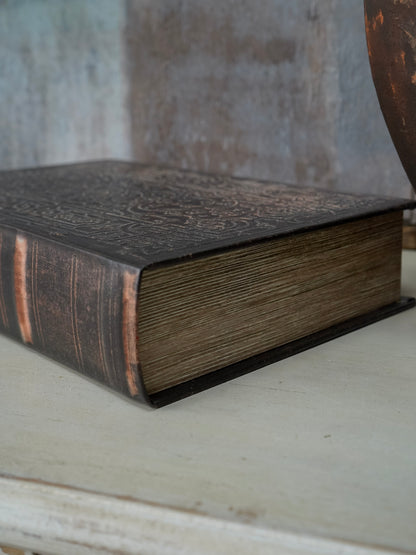 Vintage book with embossed cover on a wooden surface