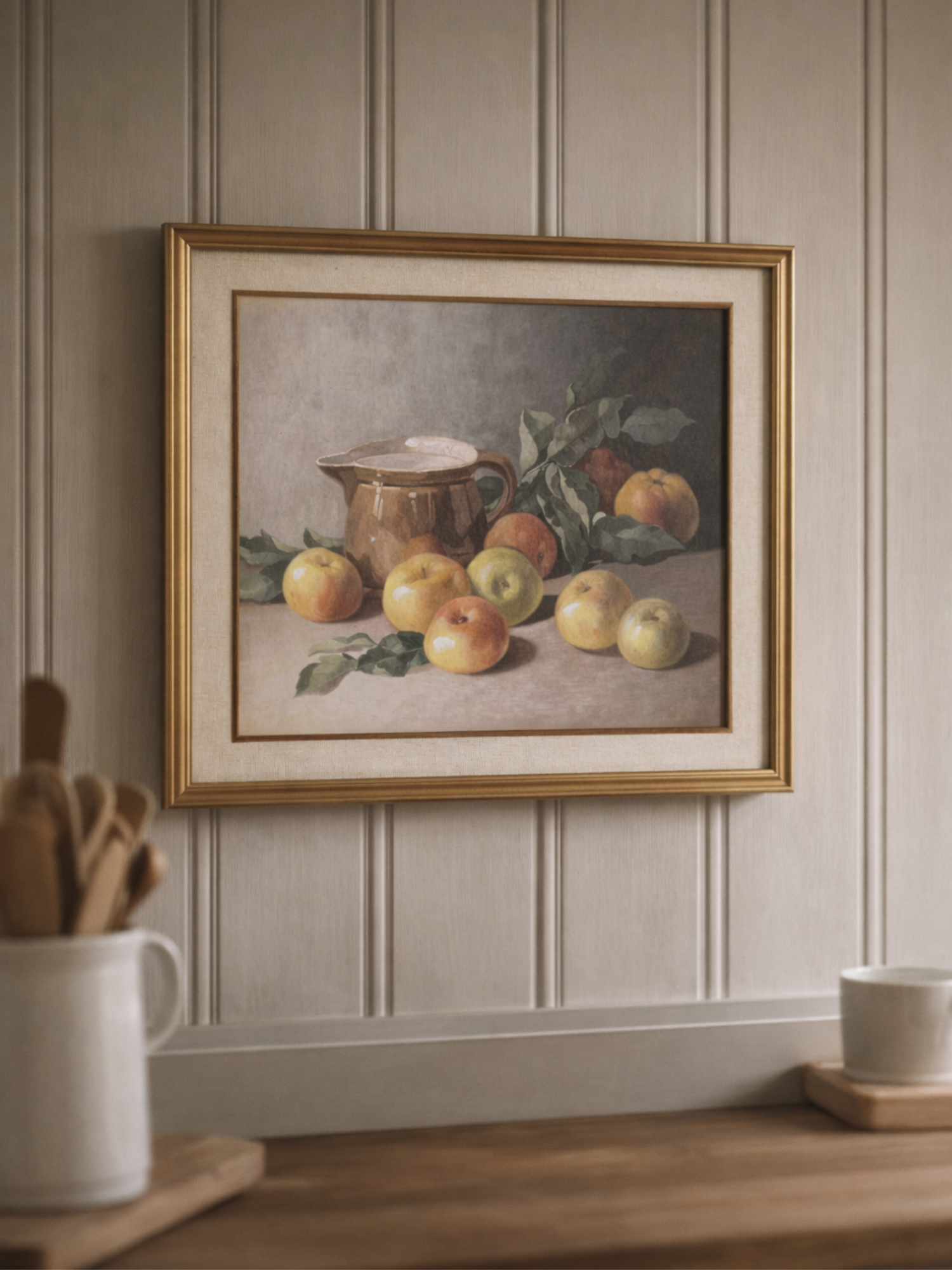 Framed still life painting of apples and a pitcher on a wall with wooden paneling.