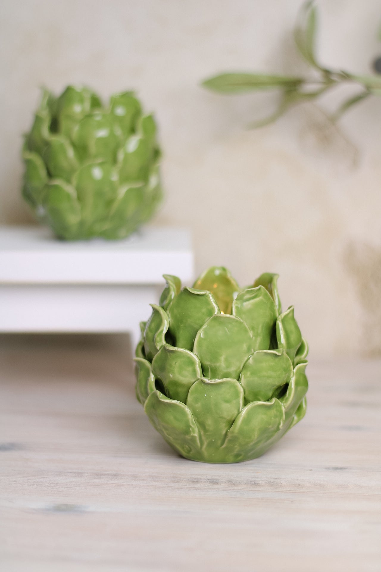 close up of green artichoke tea light holder on worktop