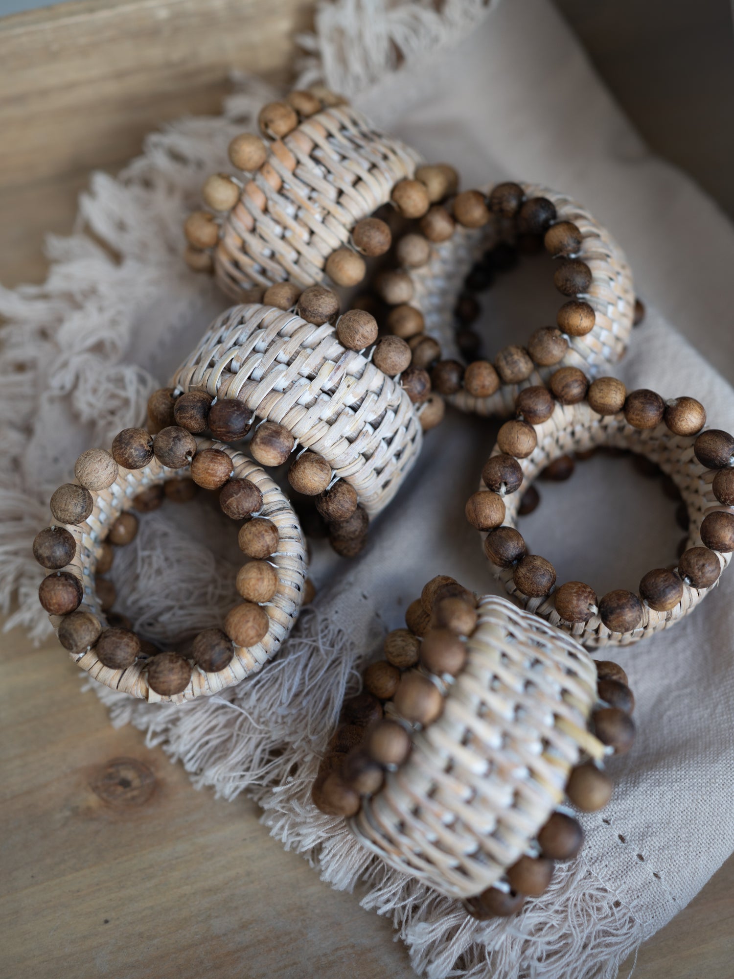 Decorative napkin rings with wooden beads on a textured surface