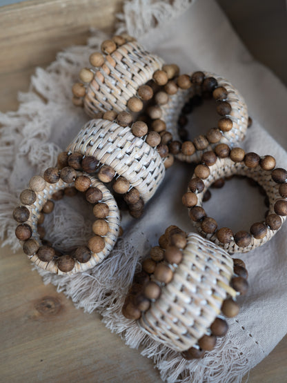 Decorative napkin rings with wooden beads on a textured surface