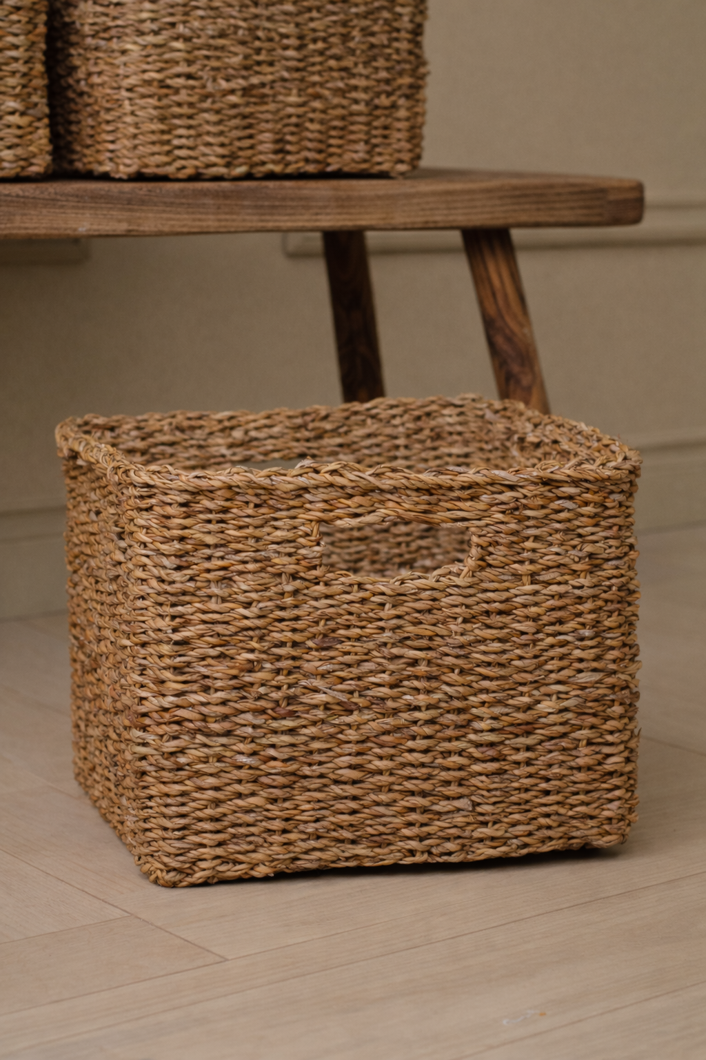 Woven basket on a wooden shelf with a neutral background