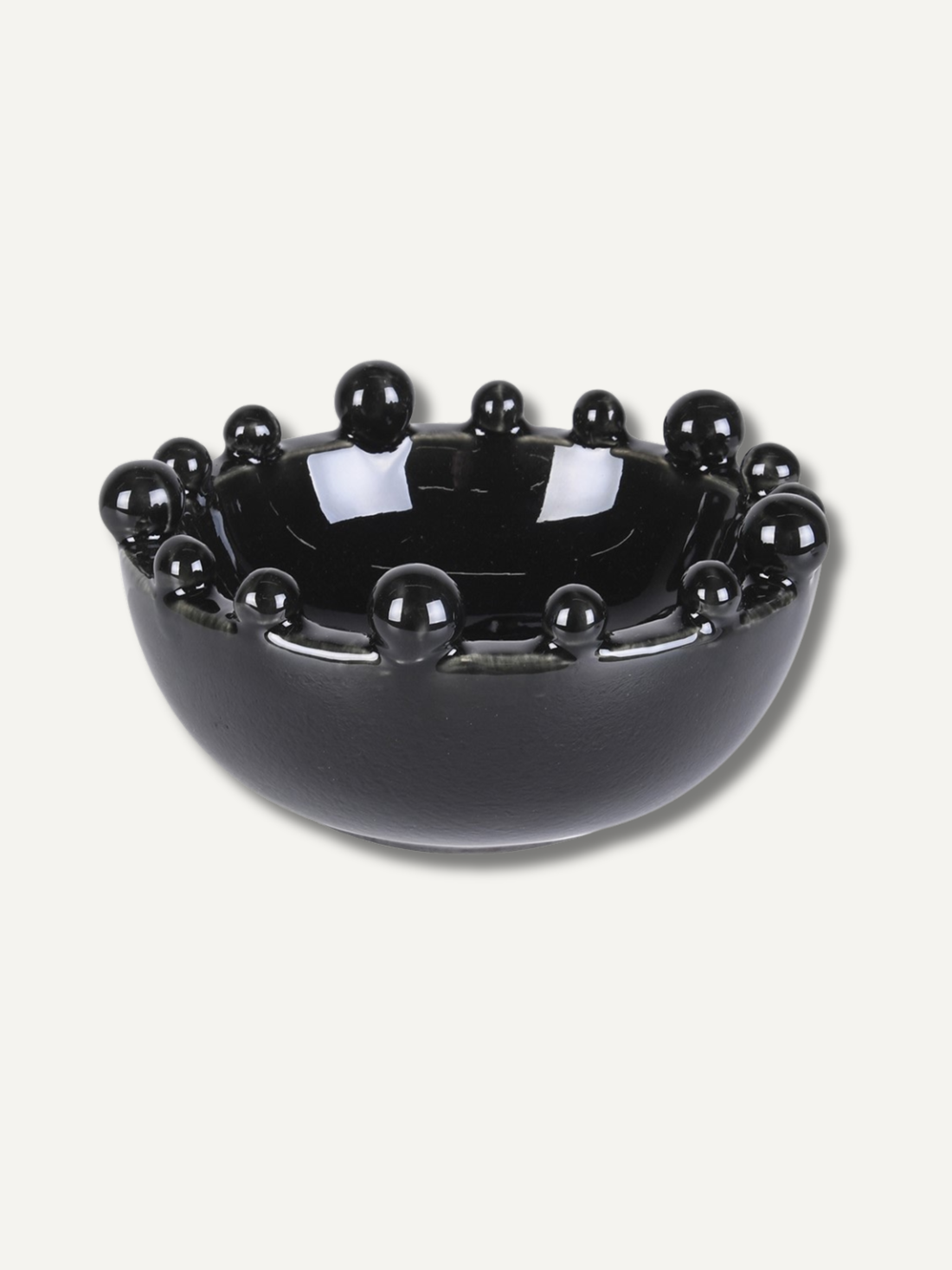 Black decorative bowl with bobbles embellishments on a white background