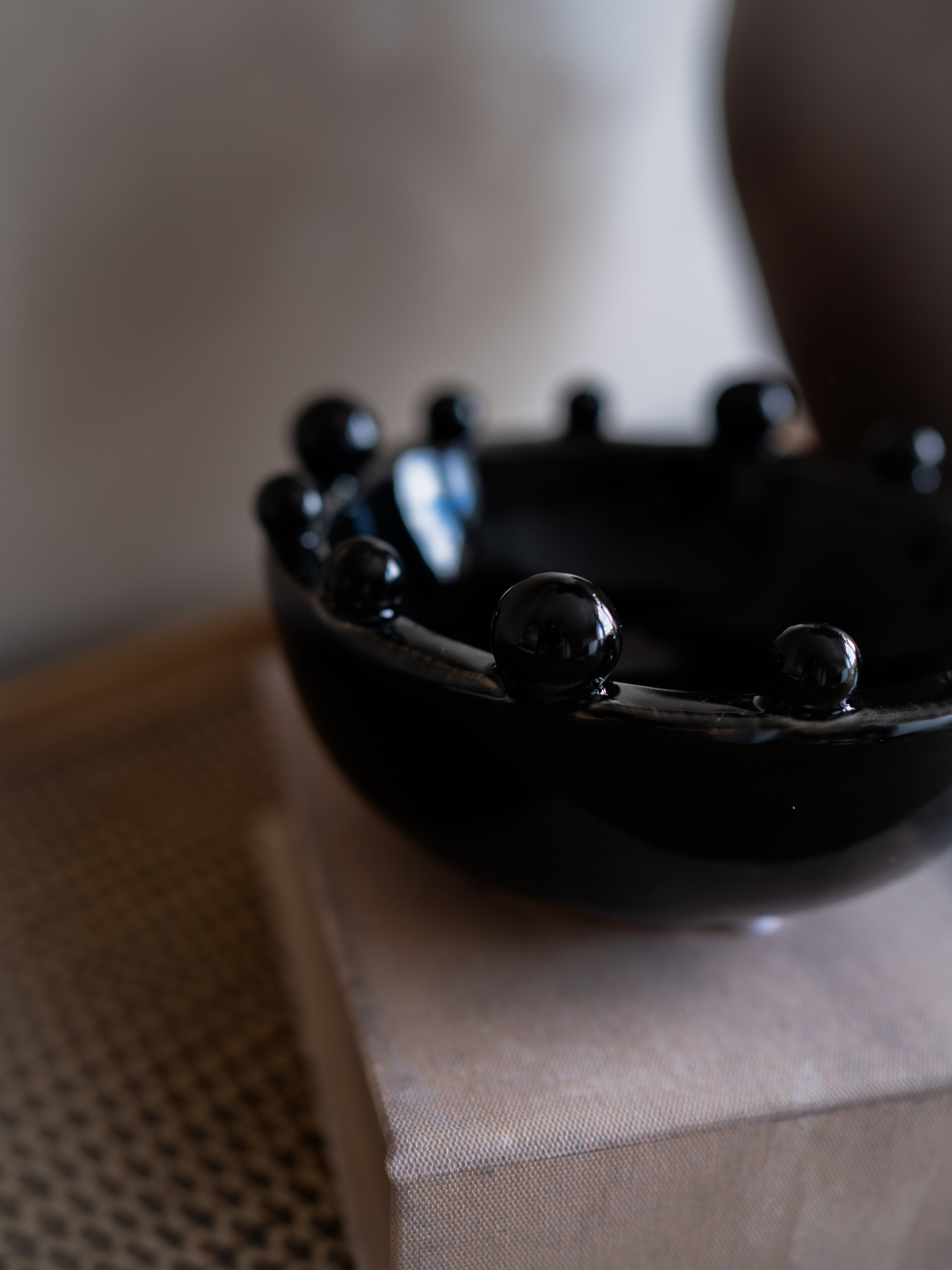 Black ceramic bowl on a textured surface with a blurred background