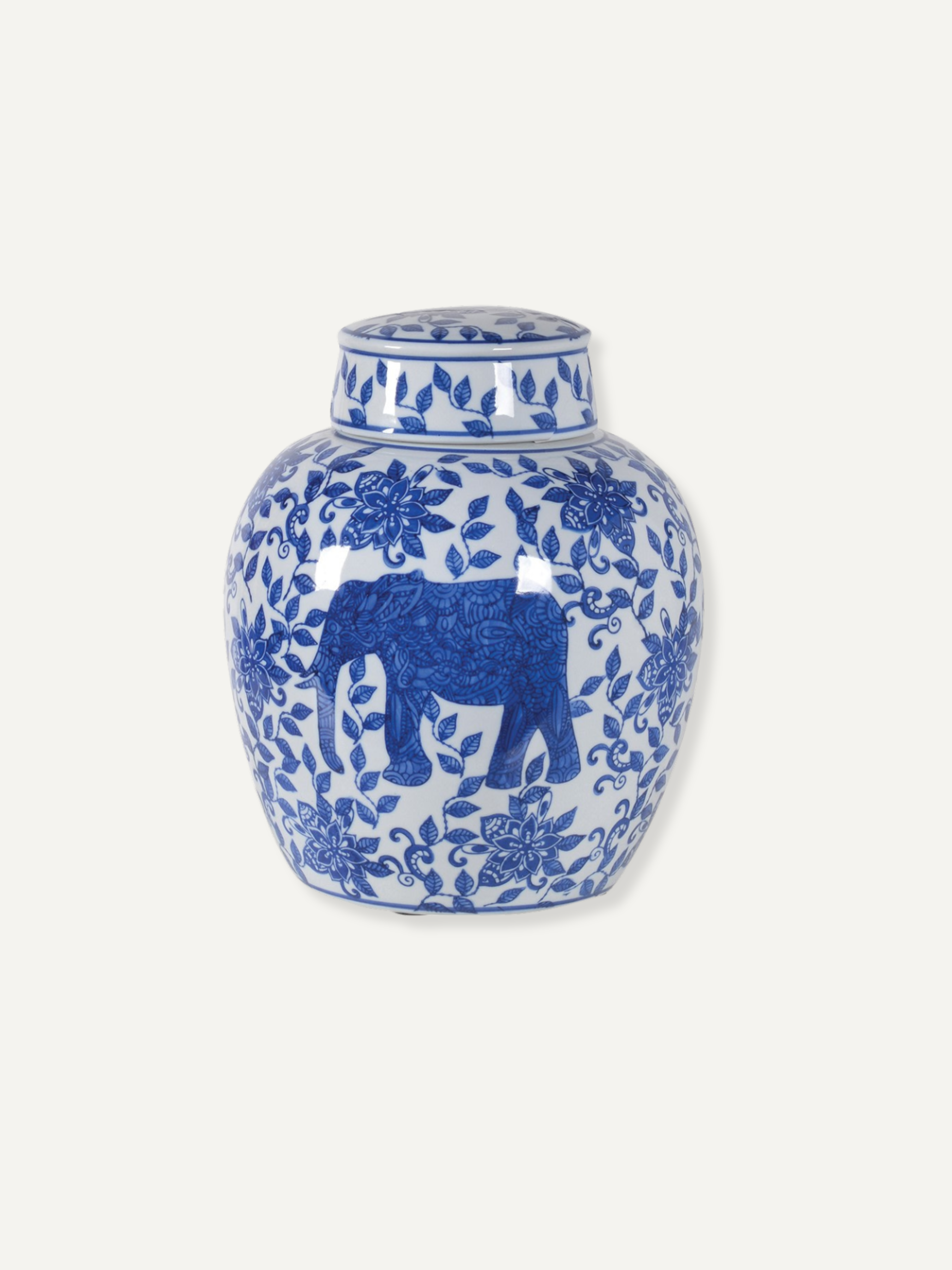 A blue and white porcelain ginger jar featuring a blue elephant motif surrounded by floral patterns, set against a solid off-white background. Timeless Chinoiserie inspired design.
