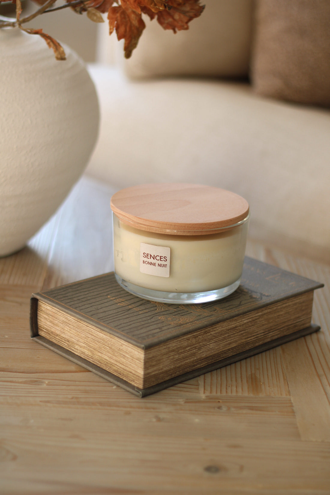 Bonne nuit lavender scented candle with wooden lid on a book in a cosy indoor setting