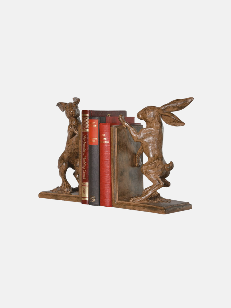Decorative bookends shaped like boxing hares holding books on a white background