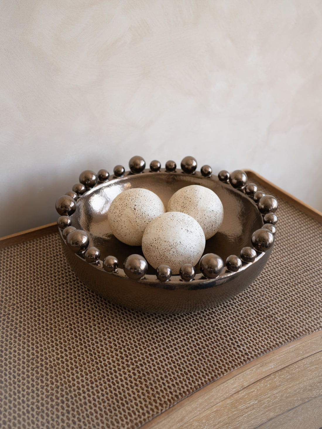 Decorative bowl with spherical stones on a textured surface
