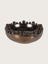 Bronze bowl with bobble embellishments on a light gray background