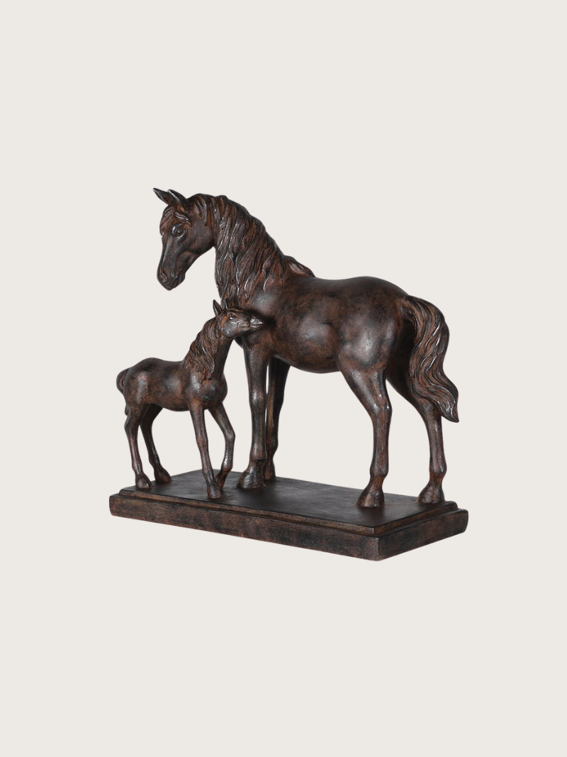 Bronze sculpture of a horse and foal on a beige background
