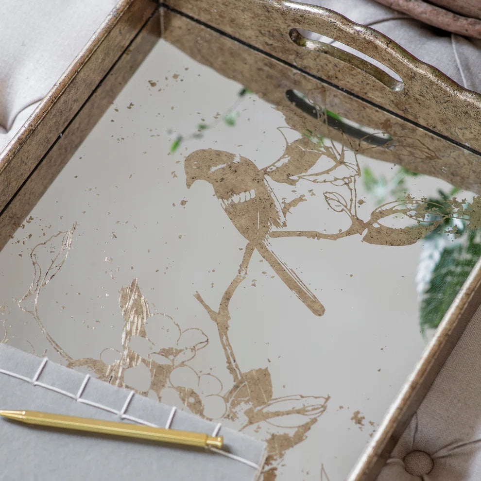 Decorative tray with gold bird design on a neutral background