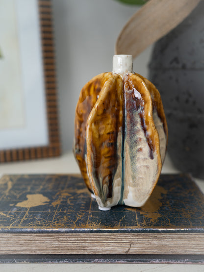 Decorative ceramic brown pod vase with a unique design on a surface