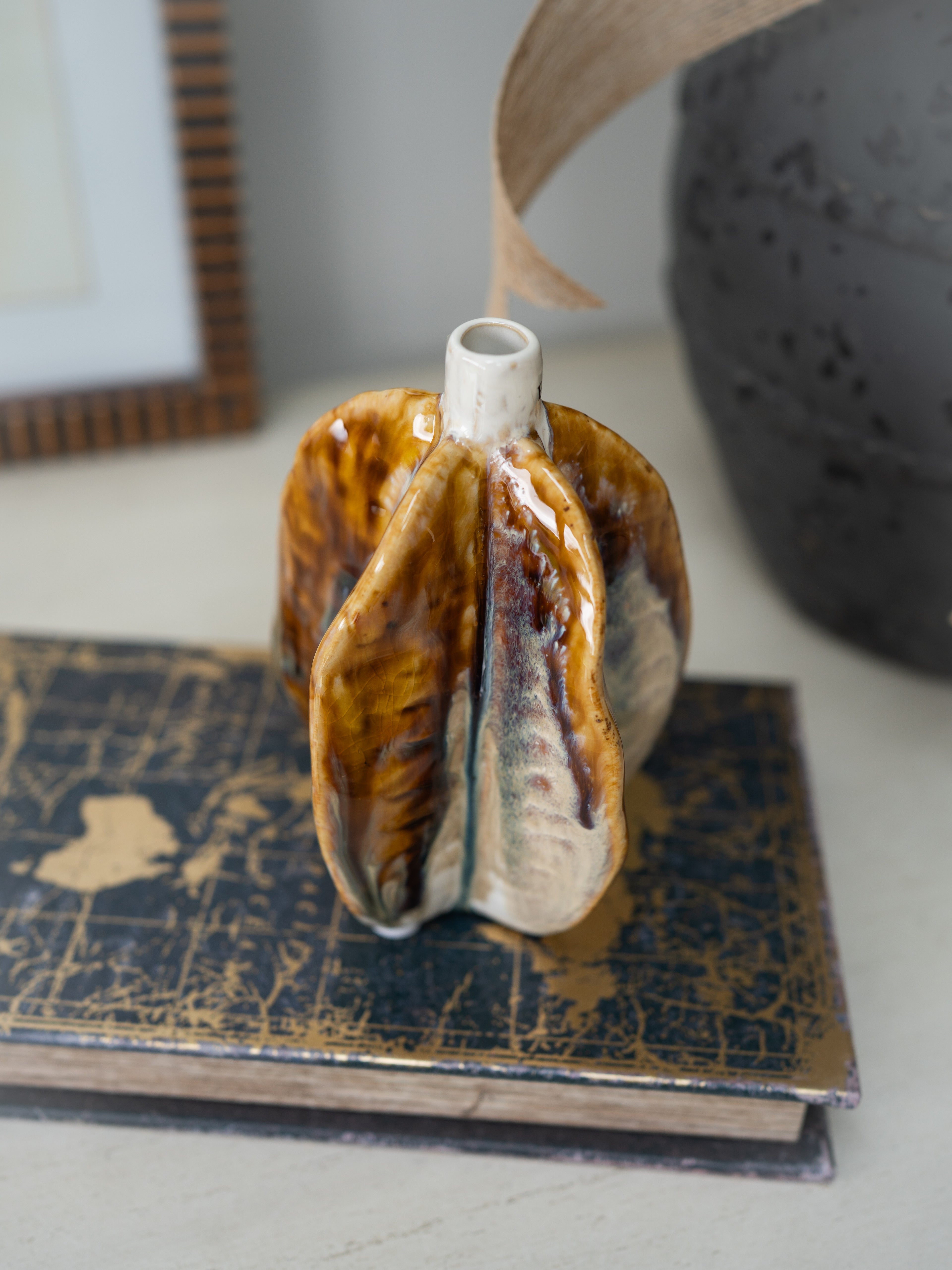 Decorative ceramic vase on a textured surface with a blurred background