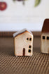 Two small ceramic houses on a textured surface with a blurred background