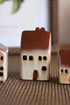 Small ceramic houses on a textured surface with a blurred background