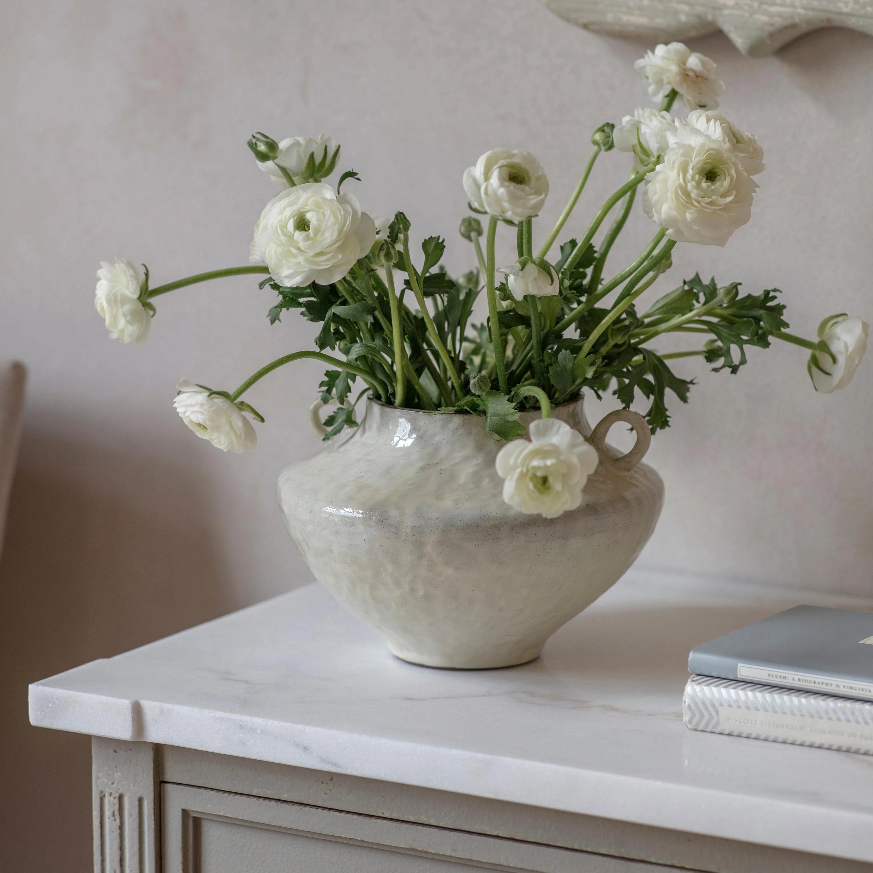 White flowers in a textured vase on a white surface with a neutral background a lovely timeless home styling piece