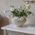 White flowers in a textured vase on a white surface with a neutral background a lovely timeless home styling piece