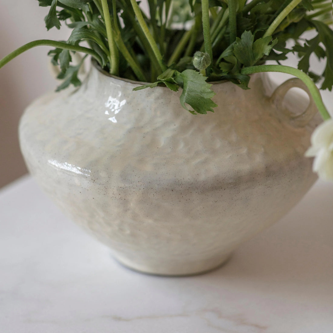 White textured vase with green plants on a marble surface beautiful timeless home decor