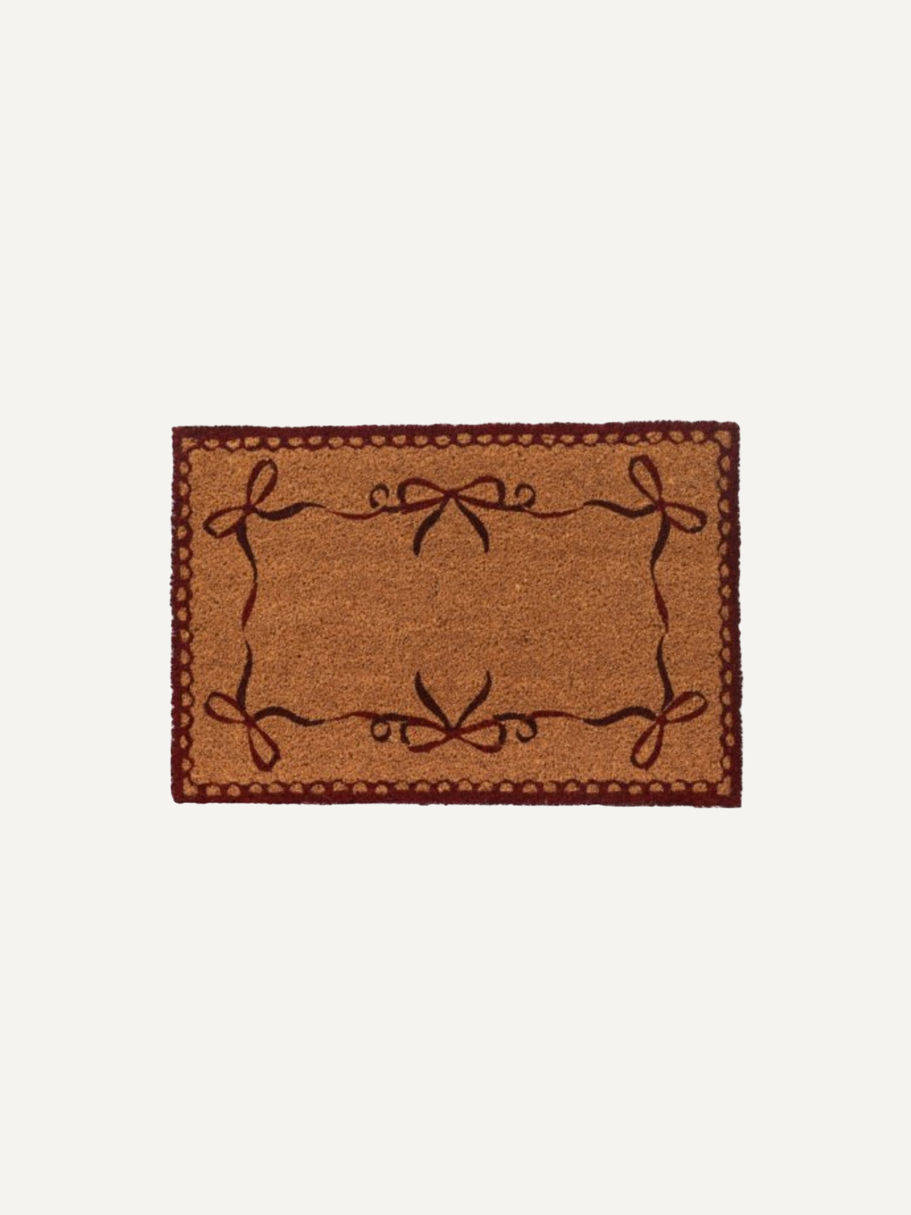 A rectangular coir doormat with a natural brown textured center, a dark reddish-brown decorative border, and dark brown embroidered bow motifs in each corner, shown against a plain off-white background.
