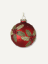 A round red Christmas ornament decorated with glittery gold holly leaves and red berry accents, hanging from a gold loop against a light gray background.