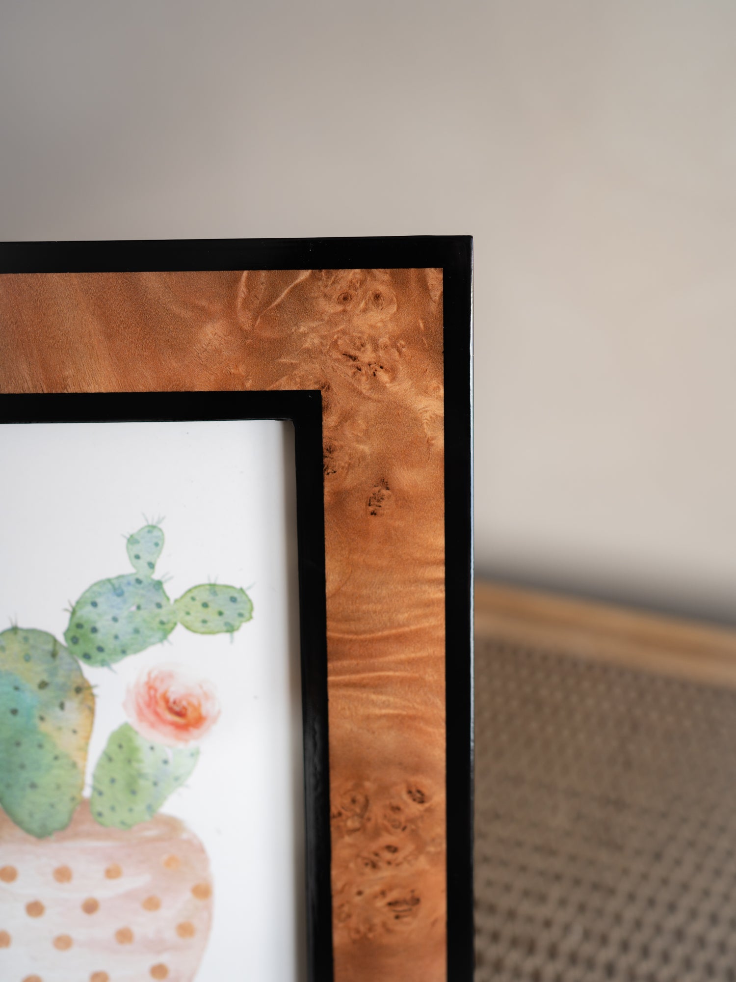 burl wood effect photo frame with a polka dot vase and cactus on a neutral background