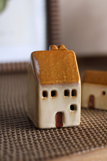 Small ceramic house figurine on a textured surface