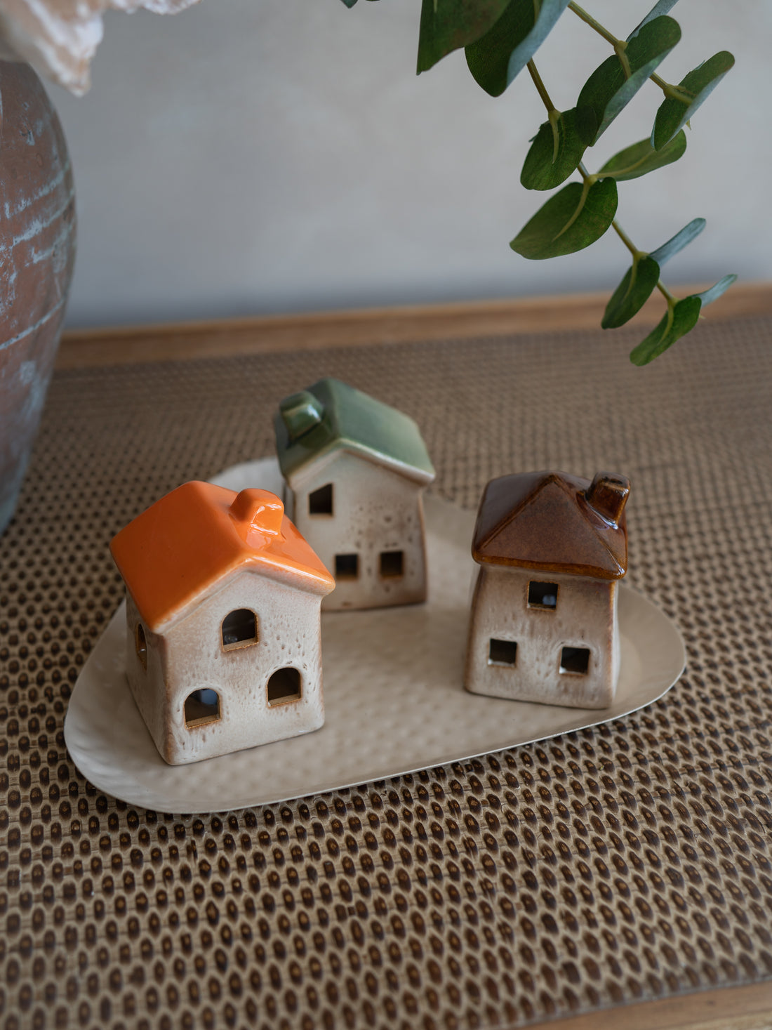 set of three ceramic houses in autumn tones on metal triangular shaped tray