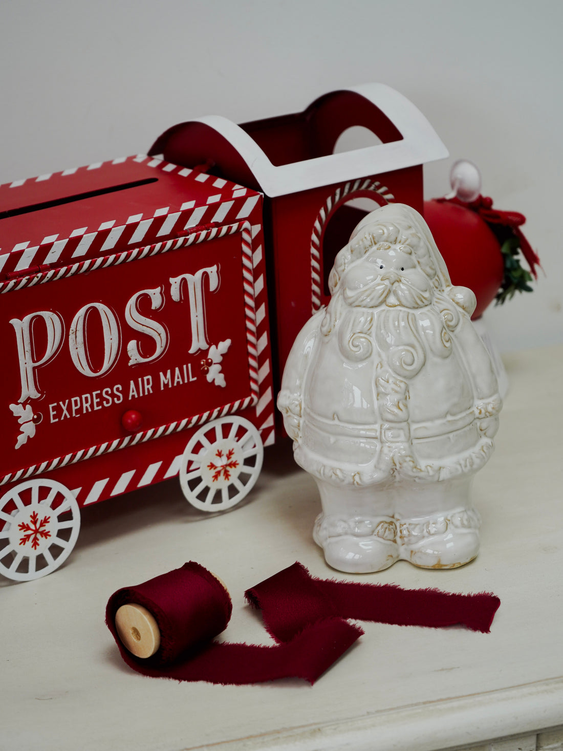 Decorative Santa figure next to a red mailbox with &