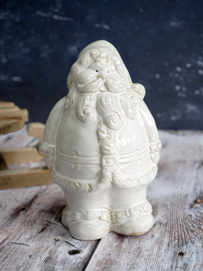 White ceramic Santa Claus figure on a wooden surface with a dark background