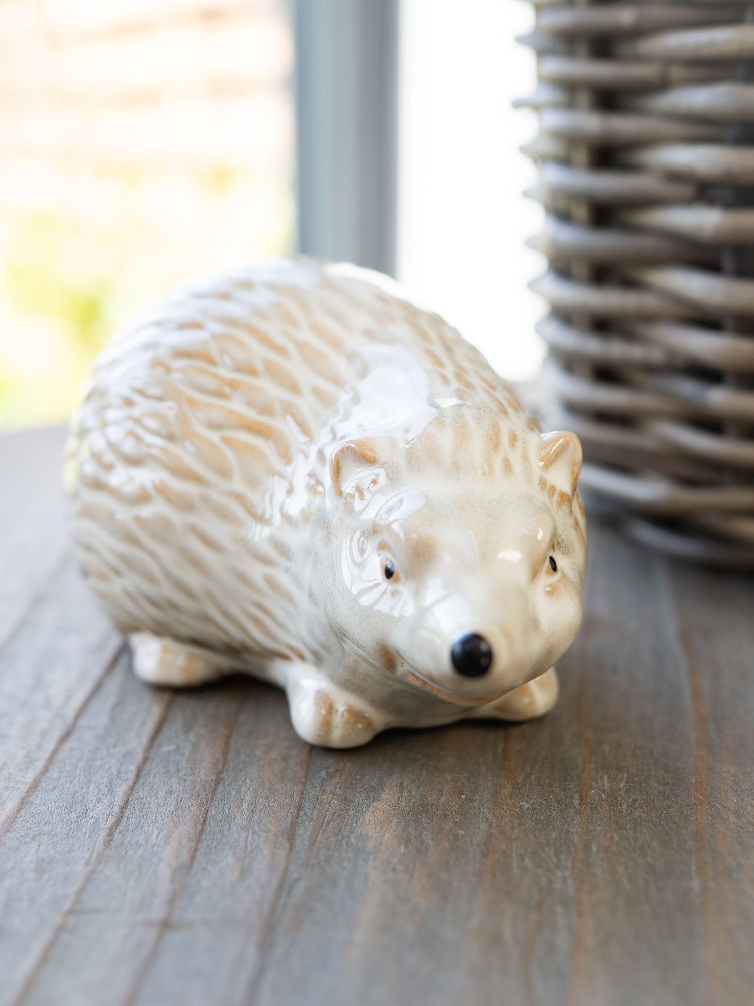 Ceramic hedgehog figurine on a wooden surface