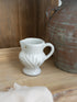 White ceramic White Leaf etched jug with decorative design on a wooden surface