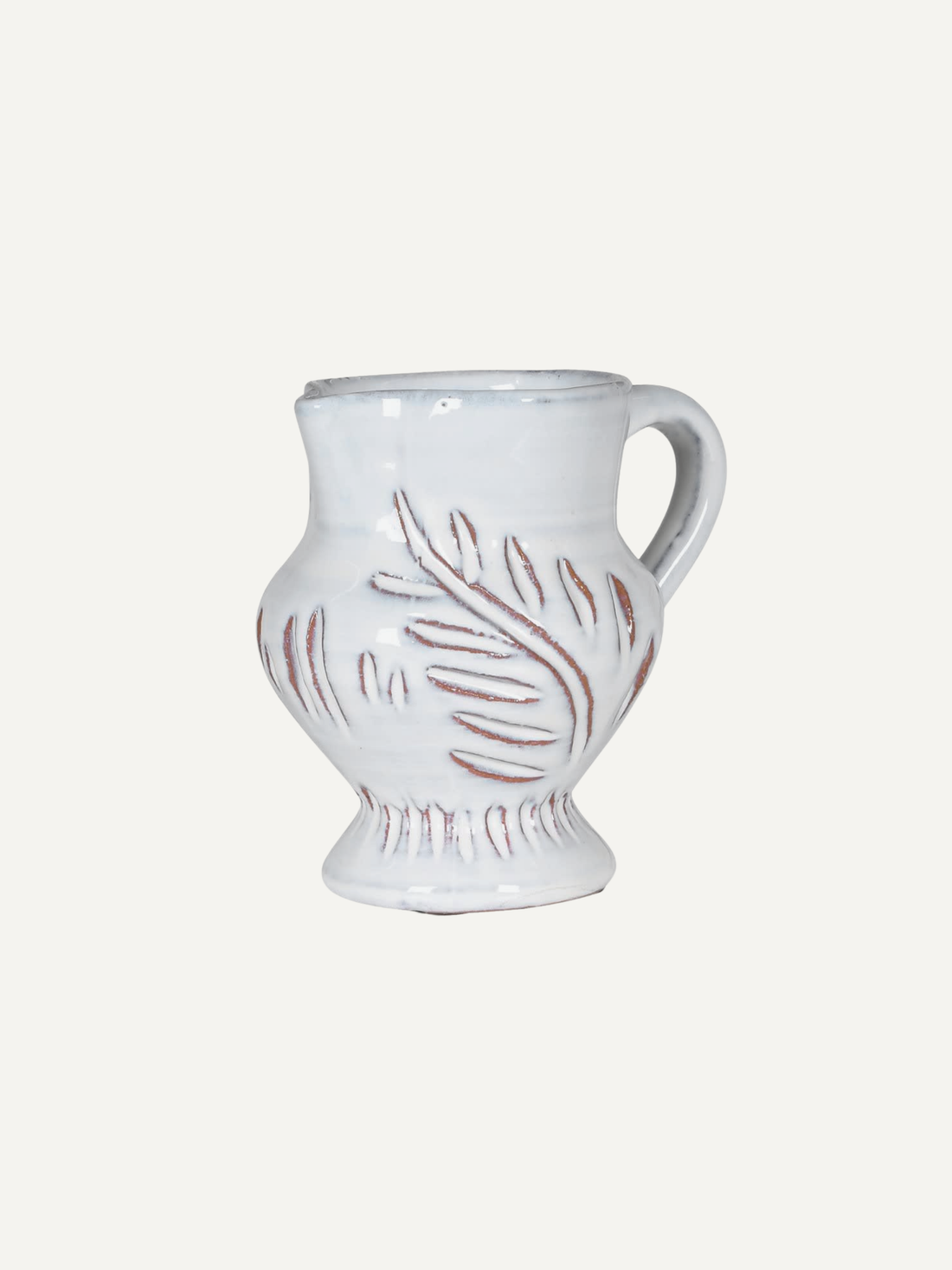 Chalk white etched leaf jug with decorative patterns on a white background