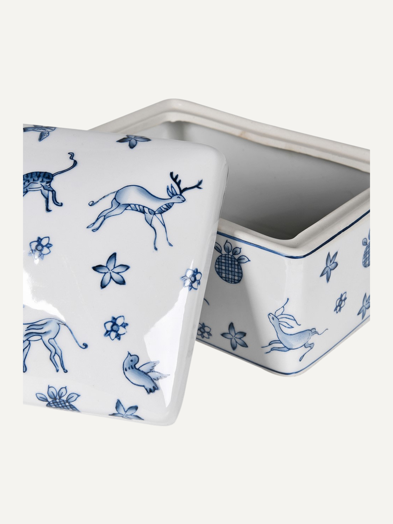 White ceramic trinket box with blue animal and floral patterns on a white background