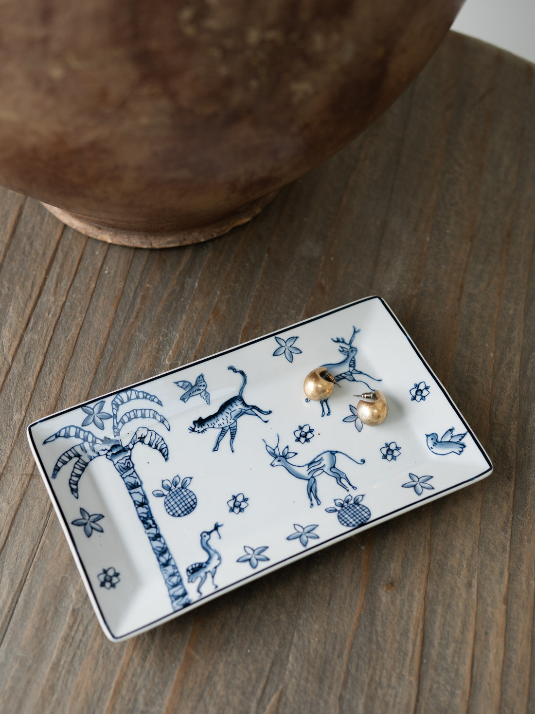 Decorative ceramic trinket tray with animal patterns on a wooden surface