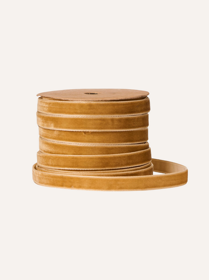 Spool of clay brown ribbon on a beige background