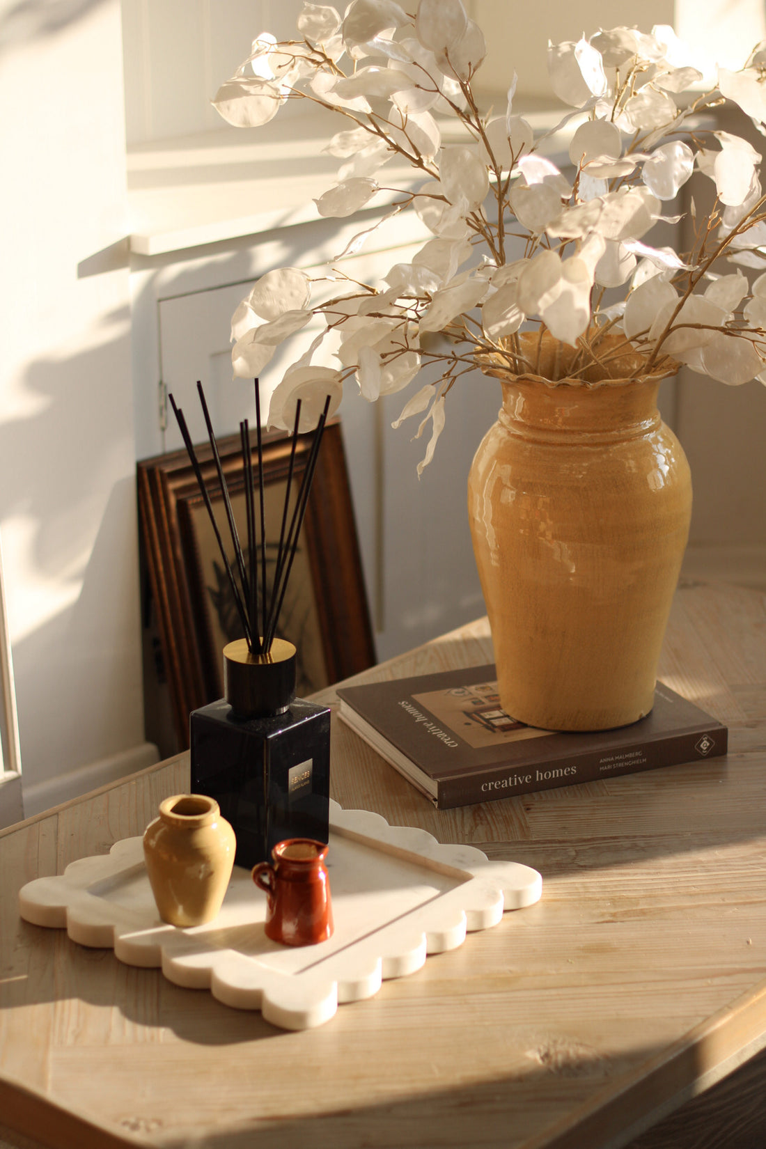 Vintage inspired coffee table styling with ochre vase and faux honest sprays
