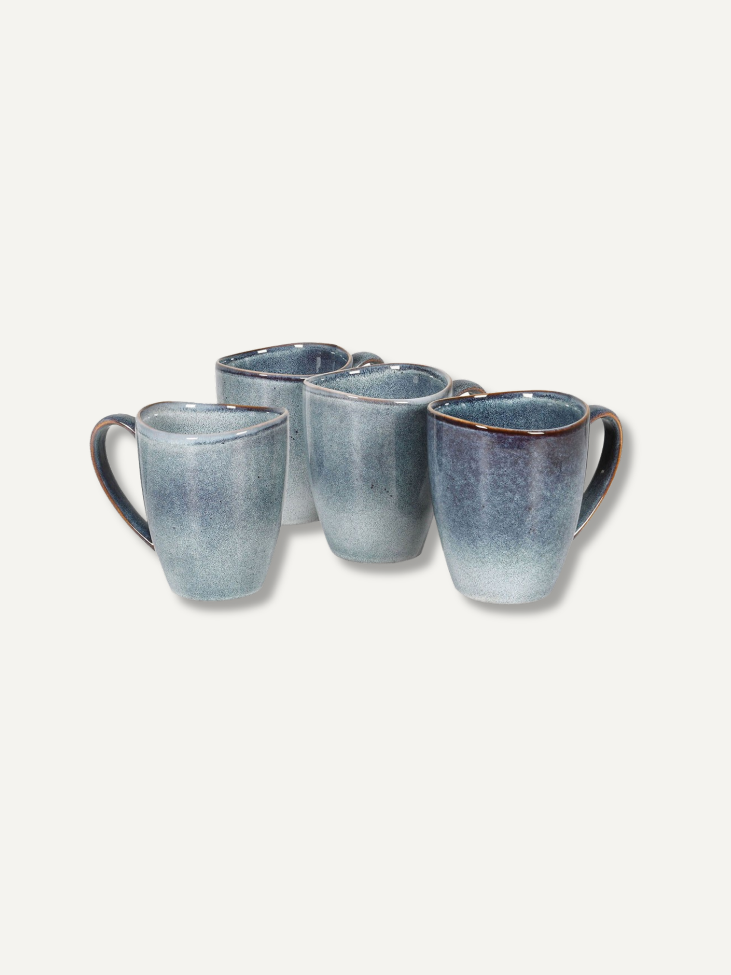 Four ceramic mugs with a blue and gray gradient glaze and dark brown handles, arranged on a light beige background.