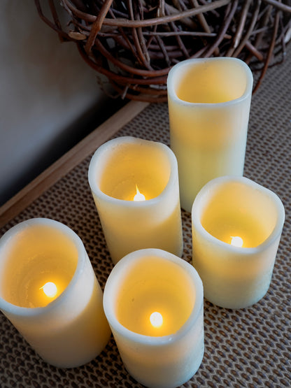 Set of five white LED candles with a wicker basket in the background