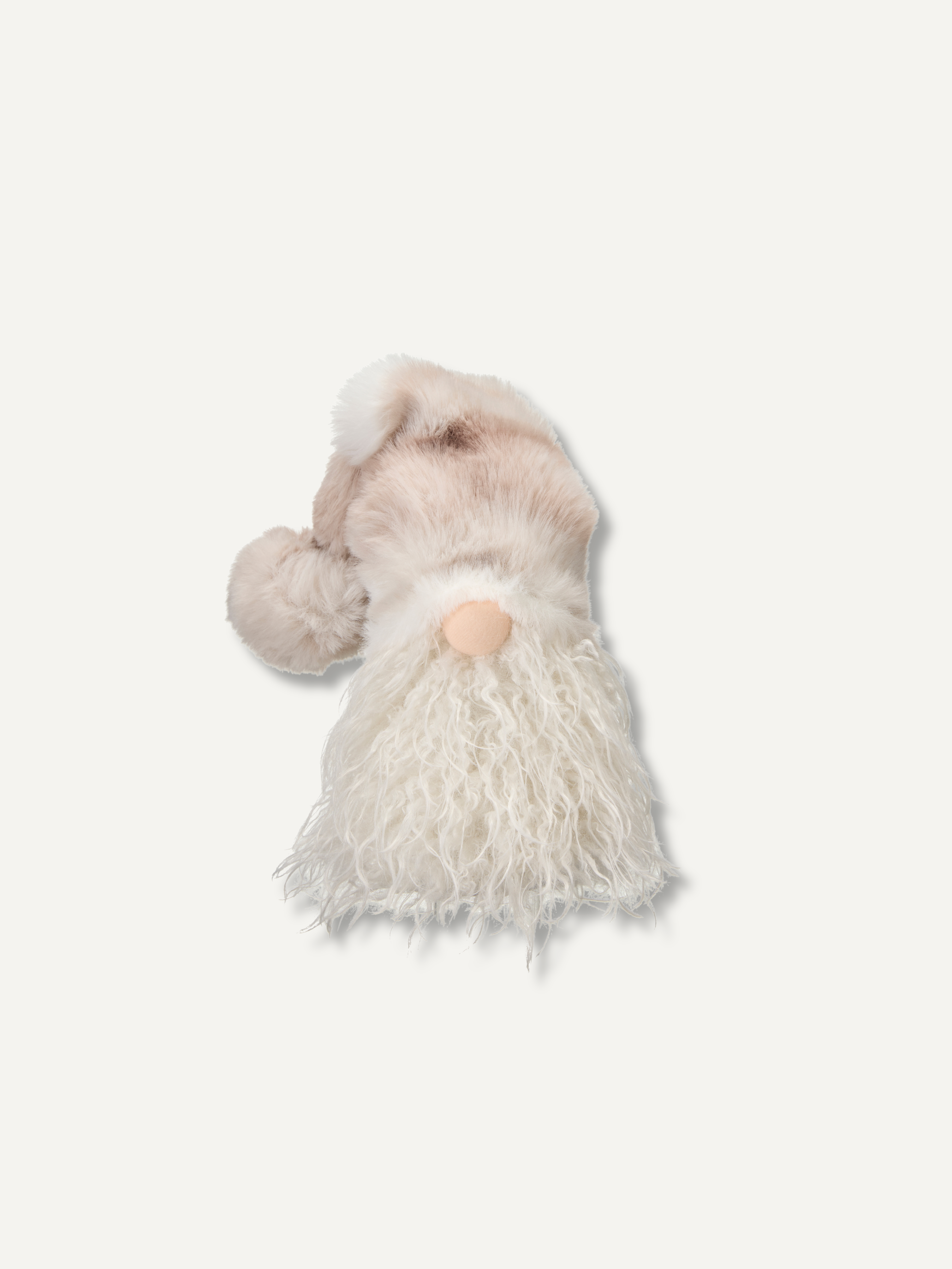 A small plush gnome figurine with a soft beige hat, fluffy white beard, and a peach-colored nose, shown against a plain off-white background.