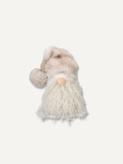 A small plush gnome figurine with a soft beige hat, fluffy white beard, and a peach-colored nose, shown against a plain off-white background.