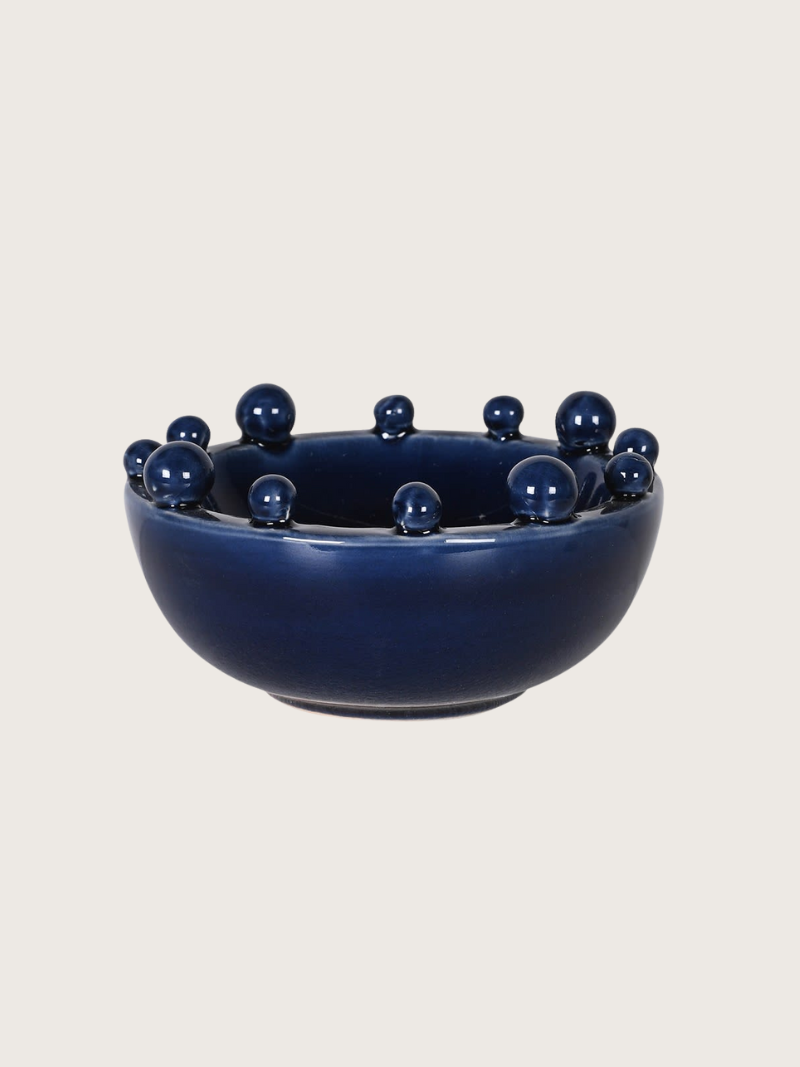 Navy blue bowl with small navy blue bobble on a light beige background