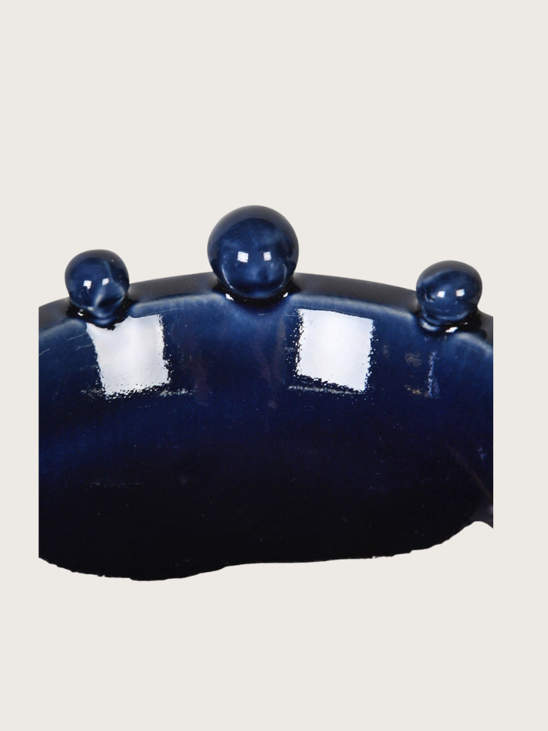 Navy bobble bowl with four small spheres on a white background