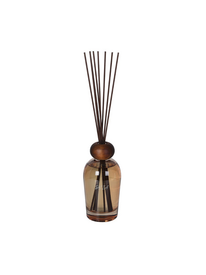 Diffuser bottle with wooden top and black sticks on a white background