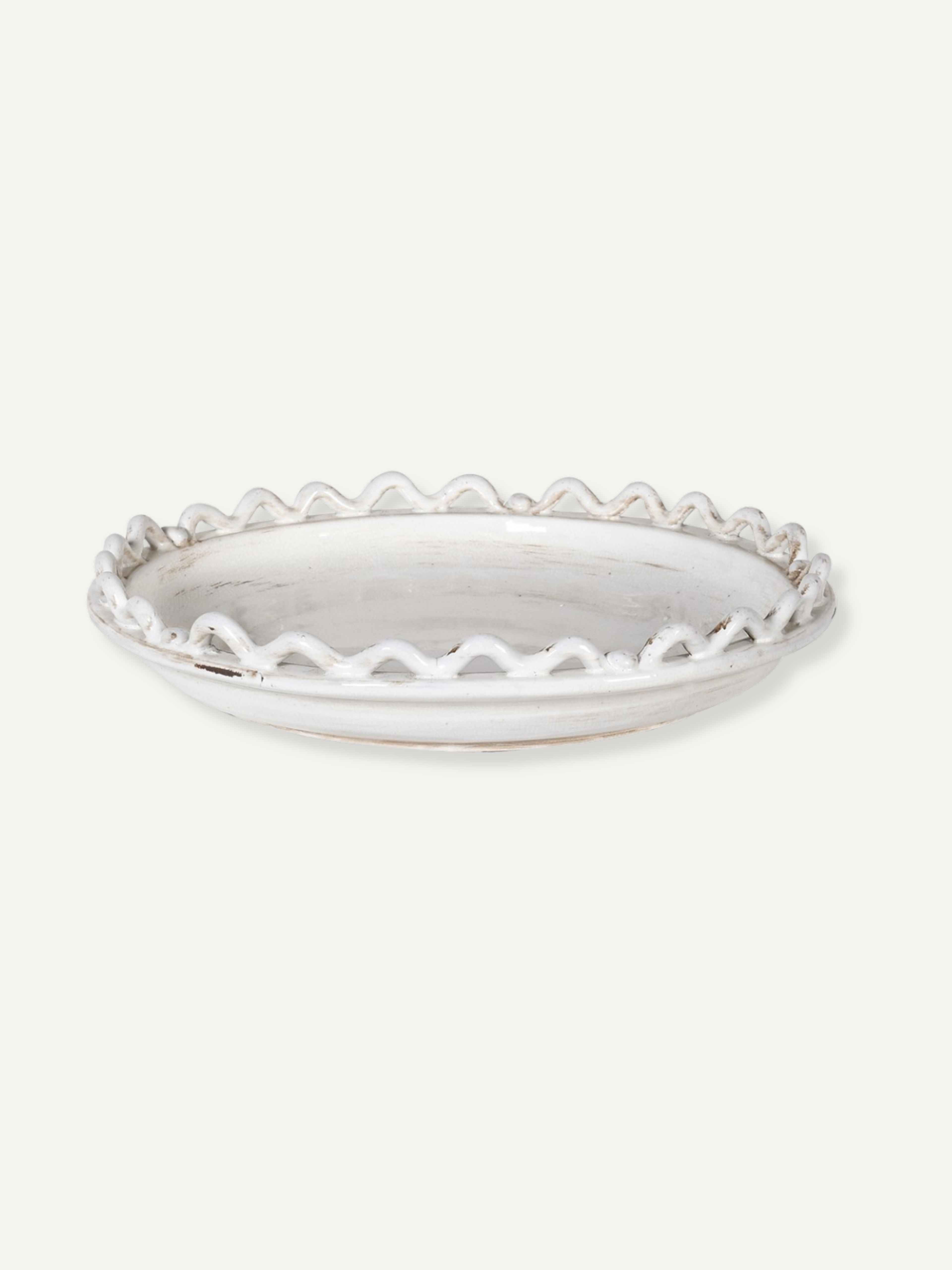 White ceramic wave and bobble bowl with decorative edge on a white background