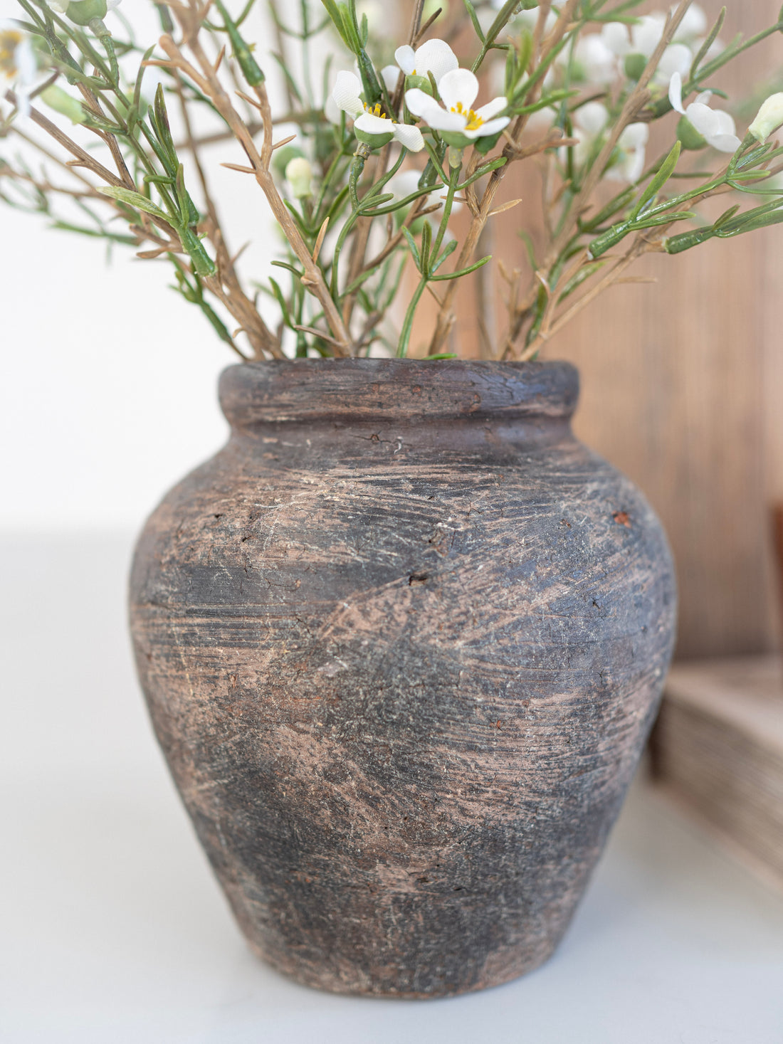Decorative stone vase with plants on a light background