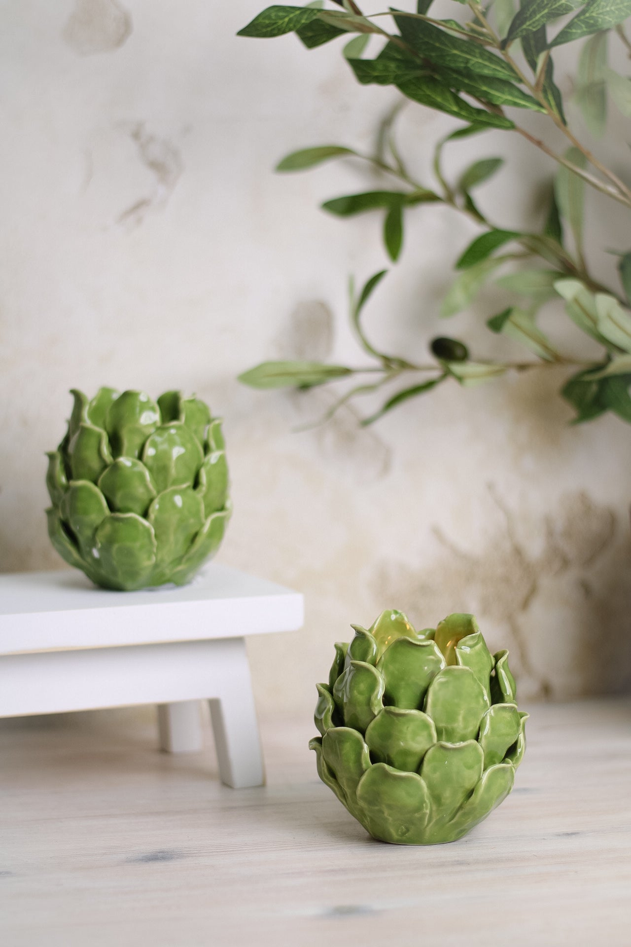 two Green Ceramic Artichoke Tea Light Holder on mini white bench