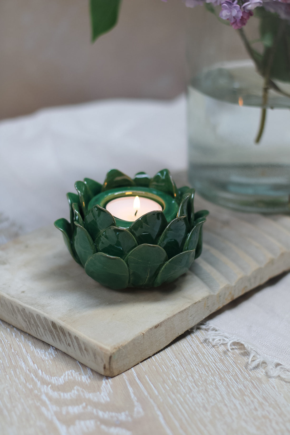 green ceramic artichoke tea light holder on vintage wooden washboard