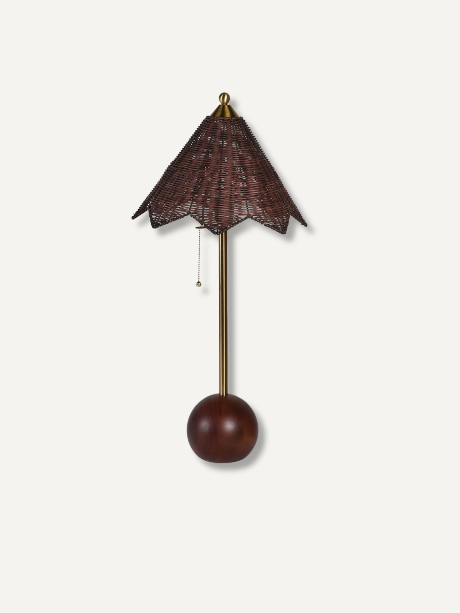 A table lamp with a dark brown woven wicker shade, a brass-colored metal stem, and a round dark brown wooden bob weight, shown against a plain off-white background.
